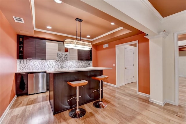 12130 Helleri Holw, Alpharetta, GA 30005 - kitchen featuring a tray ceiling, a breakfast bar area, light countertops, backsplash, and ornamental molding