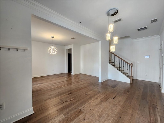 unfurnished living room featuring visible vents, crown molding, stairs, and wood-type flooring