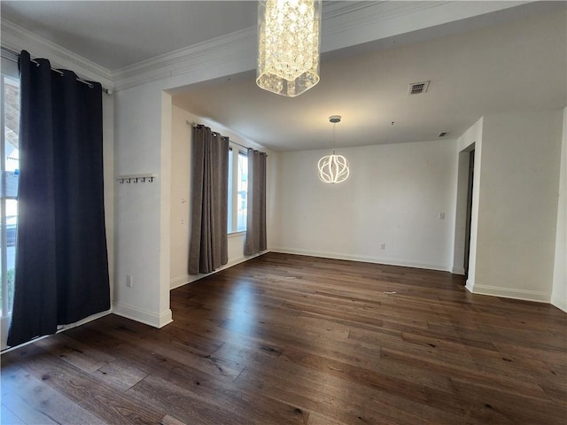 unfurnished room with visible vents, dark wood-type flooring, an inviting chandelier, crown molding, and baseboards