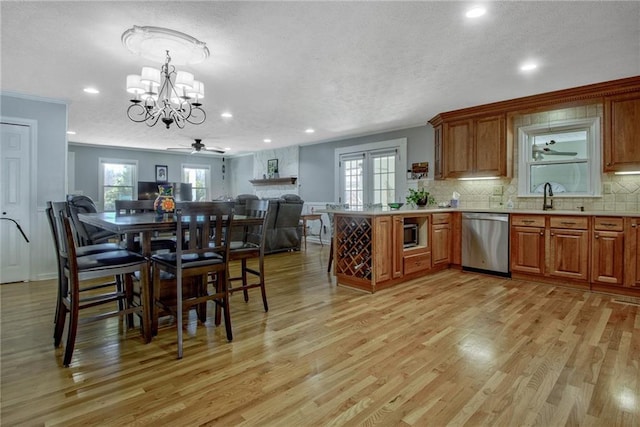 kitchen with decorative light fixtures, light hardwood / wood-style floors, decorative backsplash, and stainless steel appliances