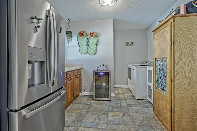 kitchen featuring stainless steel fridge with ice dispenser, a textured ceiling, wine cooler, and separate washer and dryer