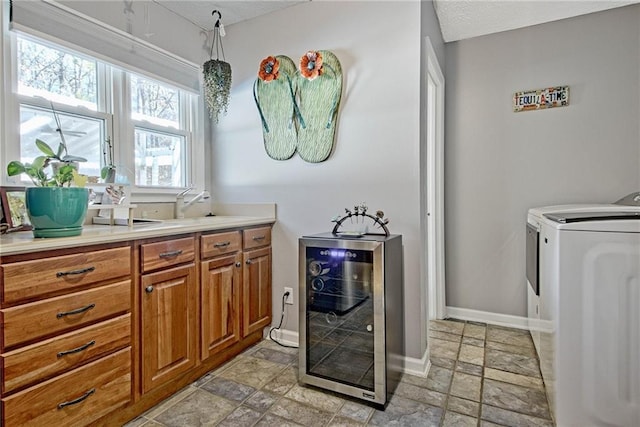 laundry area with washing machine and clothes dryer and wine cooler