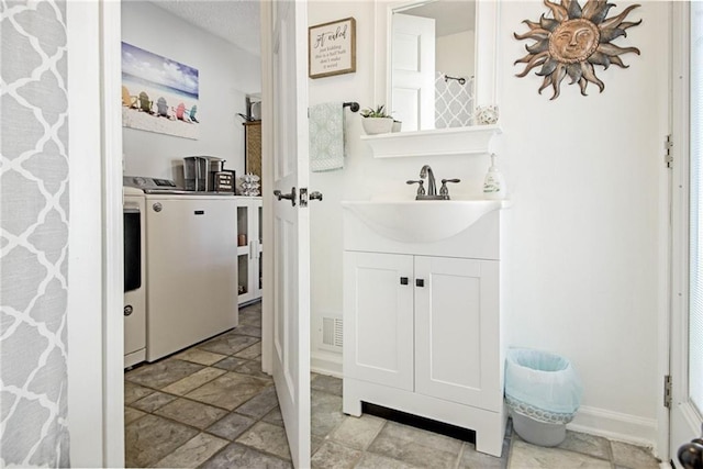 bathroom with vanity and washer and dryer