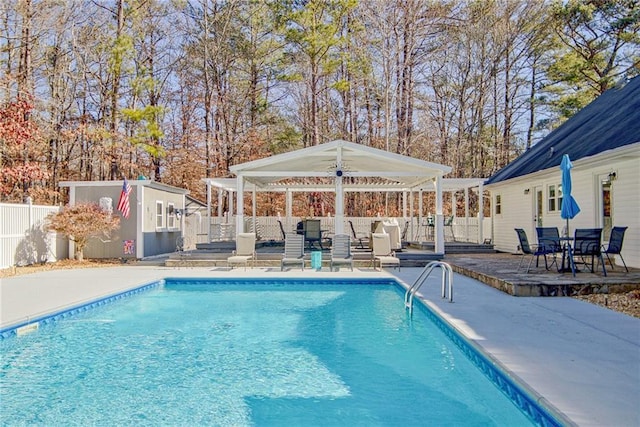 view of swimming pool featuring a patio area, a gazebo, and a storage unit