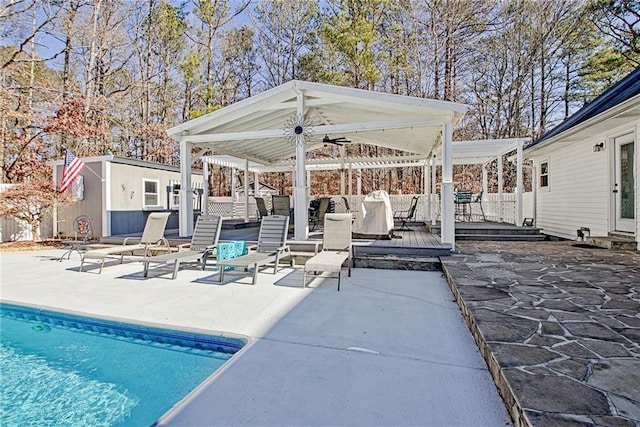 view of patio with an outdoor living space, a gazebo, a shed, ceiling fan, and a pool side deck