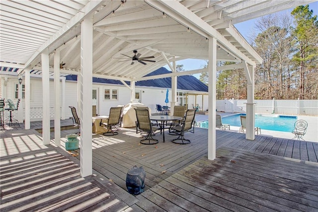 deck with ceiling fan and a fenced in pool