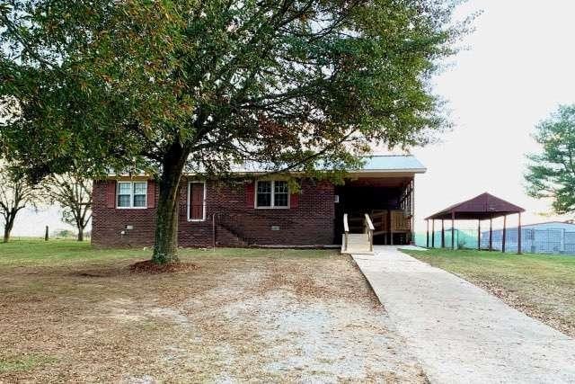 view of front of home with a front lawn and a carport