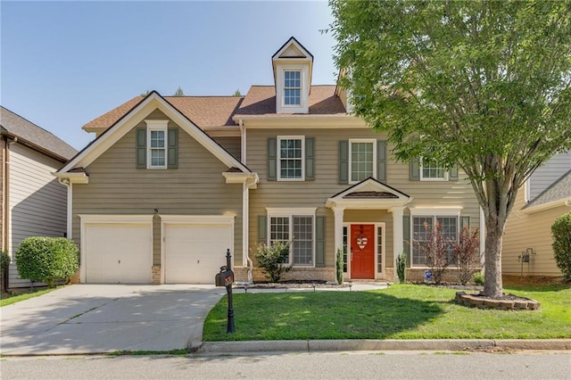 colonial-style house with a garage, concrete driveway, brick siding, and a front yard