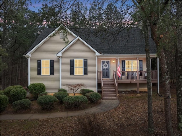 view of front of property with stairway and roof with shingles