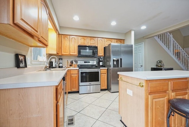 kitchen featuring light tile patterned flooring, light brown cabinets, stainless steel appliances, and sink