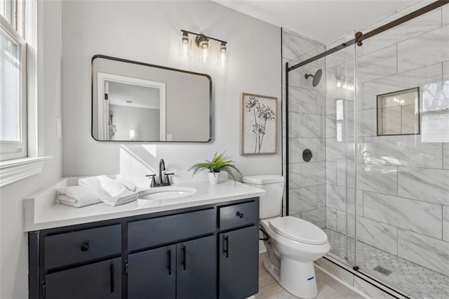 full bath featuring a stall shower, vanity, and toilet