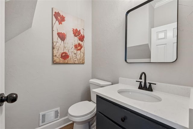 bathroom featuring visible vents, vanity, and toilet