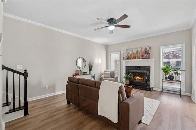 living room with stairs, ornamental molding, wood finished floors, and a high end fireplace