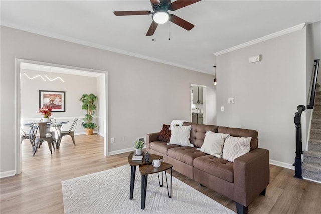 living room with crown molding, stairway, wood finished floors, and baseboards