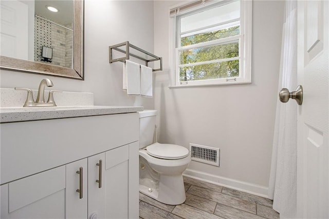 bathroom featuring vanity, toilet, and walk in shower