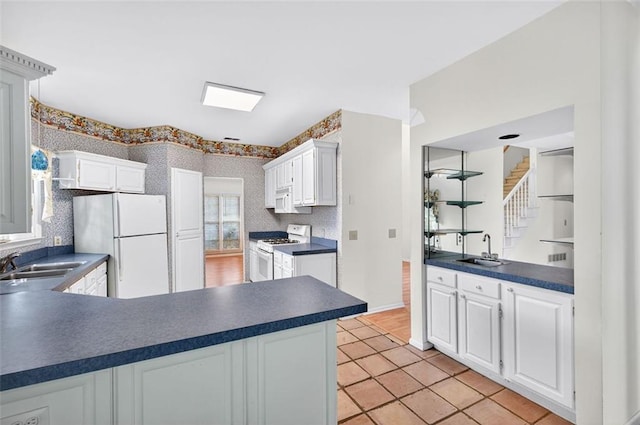2866 Wynford Dr SW, Marietta, GA 30064 - kitchen featuring white appliances, dark countertops, white cabinetry, and wallpapered walls