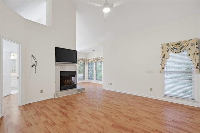2866 Wynford Dr SW, Marietta, GA 30064 - unfurnished living room with light wood finished floors, ceiling fan, a tiled fireplace, and high vaulted ceiling