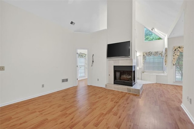 2866 Wynford Dr SW, Marietta, GA 30064 - unfurnished living room featuring high vaulted ceiling, light wood-style flooring, and a tiled fireplace