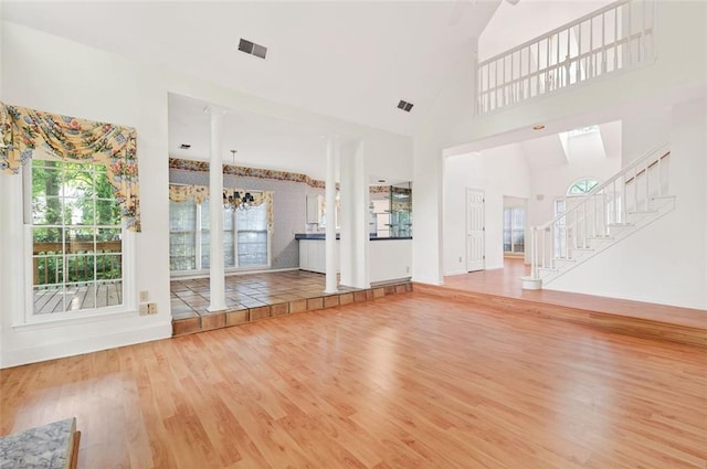 2866 Wynford Dr SW, Marietta, GA 30064 - unfurnished living room with wood finished floors, high vaulted ceiling, a chandelier, plenty of natural light, and stairway