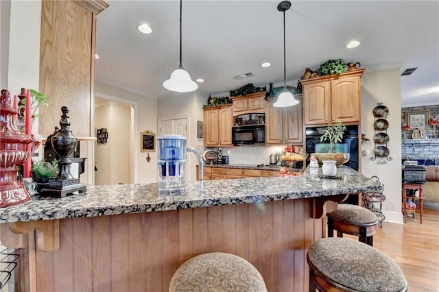 kitchen featuring backsplash, black appliances, hanging light fixtures, light wood-type flooring, and kitchen peninsula