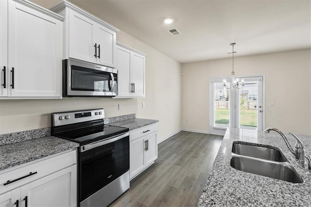 2296 Waycross Ln, Dacula, GA 30019 - kitchen featuring appliances with stainless steel finishes, a sink, wood finished floors, a chandelier, and white cabinetry