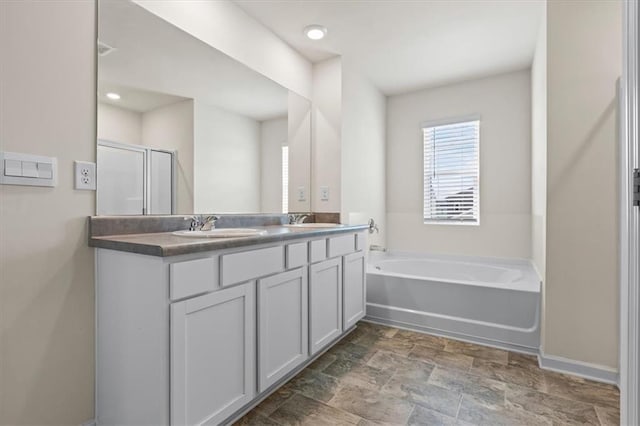 2296 Waycross Ln, Dacula, GA 30019 - full bathroom featuring a garden tub, double vanity, a shower stall, stone finish flooring, and baseboards