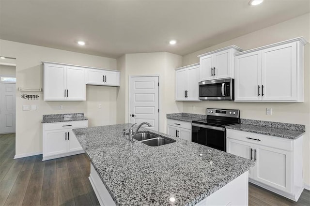 2296 Waycross Ln, Dacula, GA 30019 - kitchen with stainless steel appliances, a sink, white cabinetry, dark wood finished floors, and a kitchen island with sink