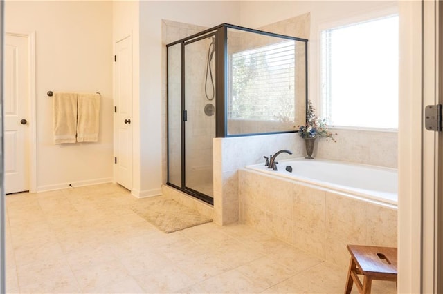 bathroom featuring a garden tub, a wealth of natural light, and a shower stall