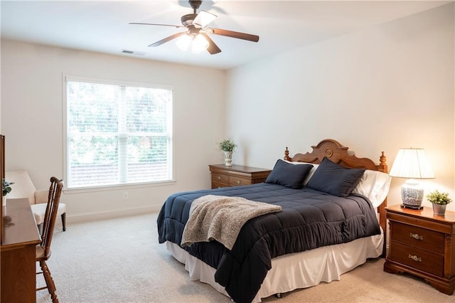 bedroom with baseboards, visible vents, light carpet, and ceiling fan