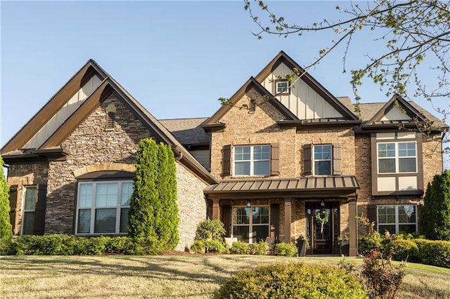 craftsman inspired home featuring board and batten siding, a front yard, a standing seam roof, and stone siding