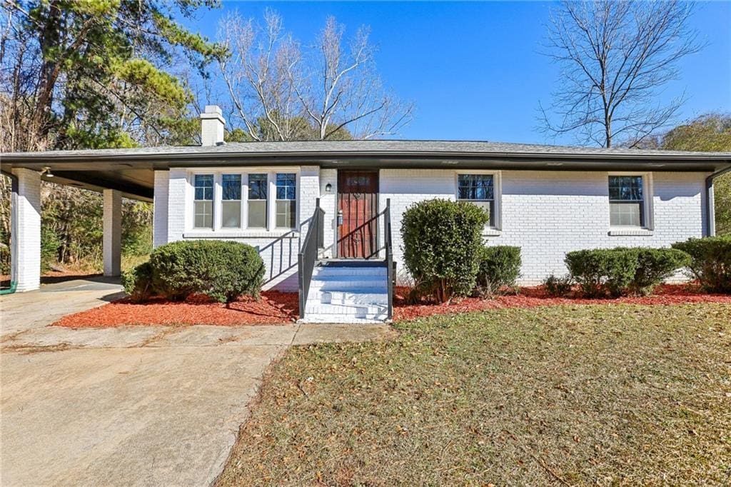 ranch-style home with a carport and a front lawn