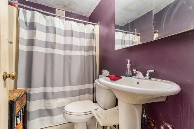 bathroom featuring a shower with shower curtain and toilet