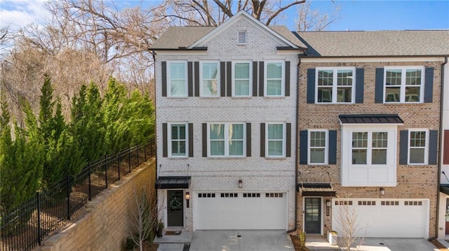 view of front of home featuring a garage, fence, brick siding, and driveway