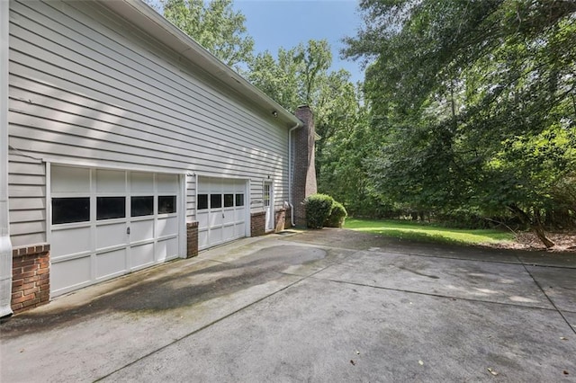 1487 W Bend Creek Ct, Atlanta, GA 30338 - view of side of property with concrete driveway, brick siding, a garage, and a chimney