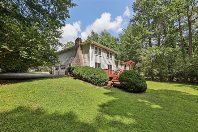1487 W Bend Creek Ct, Atlanta, GA 30338 - back of property with a chimney, a garage, a lawn, a wooden deck, and asphalt driveway