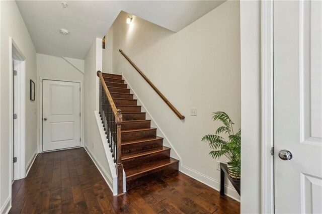 staircase featuring wood-type flooring and baseboards