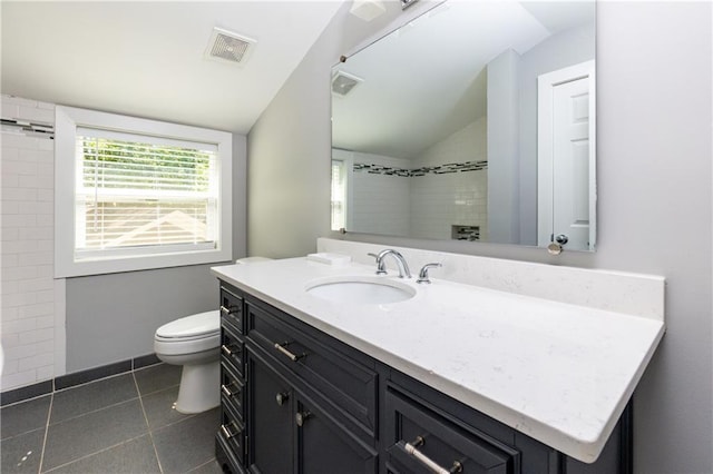 bathroom featuring tile patterned flooring, vanity, toilet, and vaulted ceiling