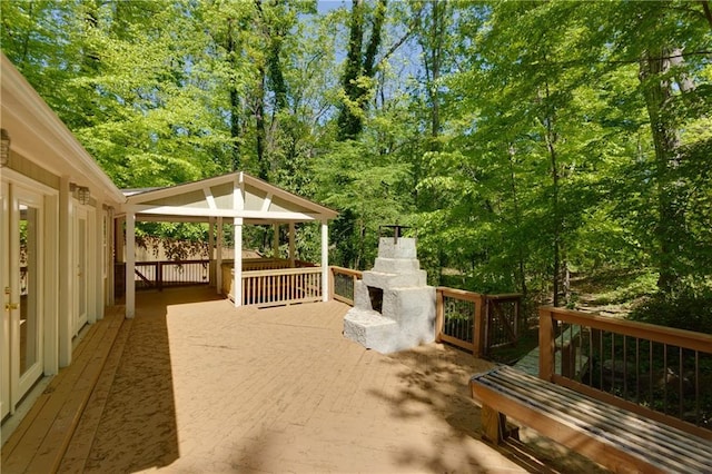 wooden terrace featuring a fireplace and a gazebo