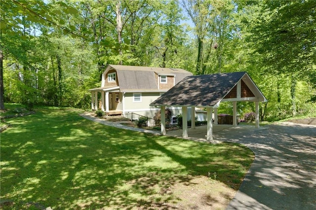 rear view of property featuring a carport and a yard