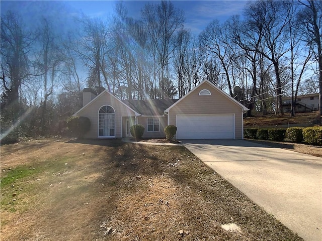 view of front of home with a garage, driveway, and a chimney