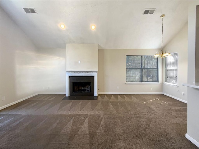 unfurnished living room with visible vents, carpet floors, an inviting chandelier, a fireplace with flush hearth, and vaulted ceiling