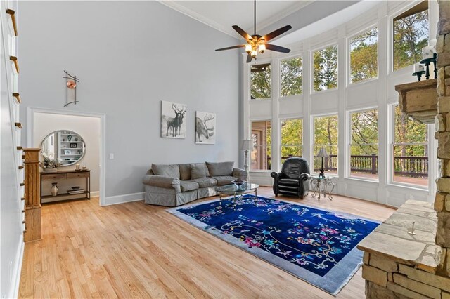 519 River Estates Parkway, Canton, GA 30115 - living room featuring crown molding, baseboards, a high ceiling, a ceiling fan, and light wood-style flooring