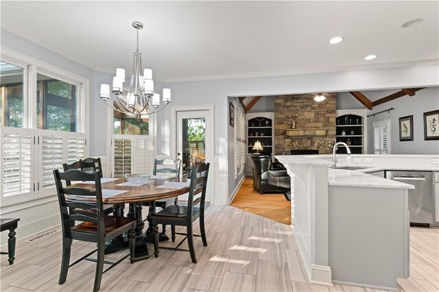 519 River Estates Parkway, Canton, GA 30115 - dining room with ornamental molding, built in features, a fireplace, light wood-type flooring, and a chandelier