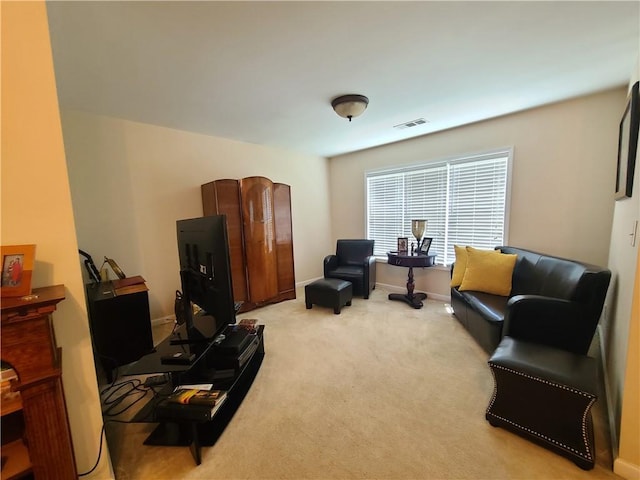 living area with light colored carpet, visible vents, and baseboards