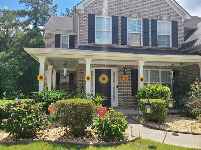 view of front of home with covered porch and brick siding