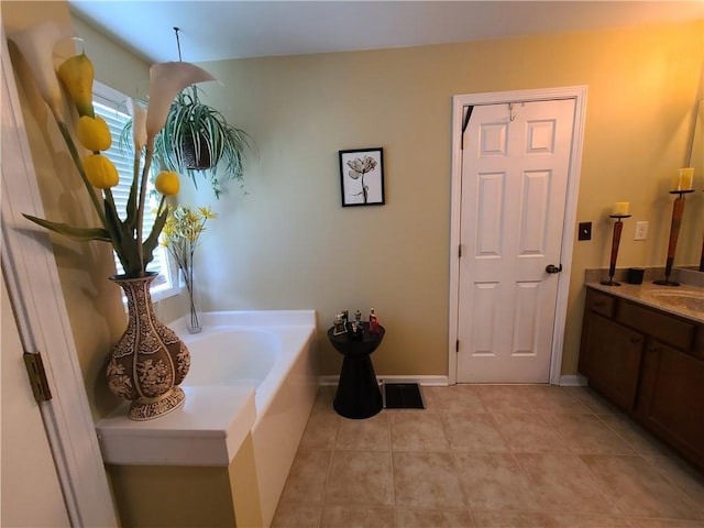 bathroom with vanity, baseboards, a bath, and tile patterned floors