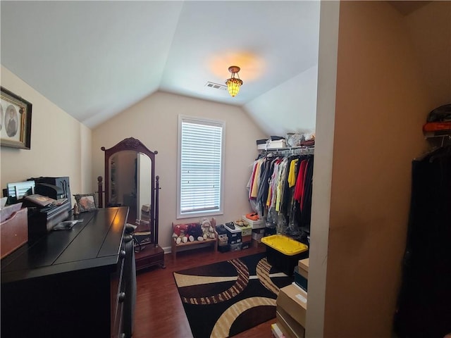 walk in closet with lofted ceiling, dark wood finished floors, and visible vents