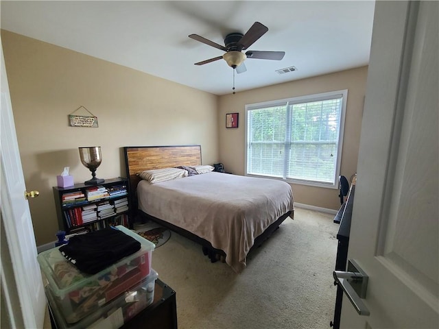 bedroom featuring light carpet, baseboards, visible vents, and a ceiling fan