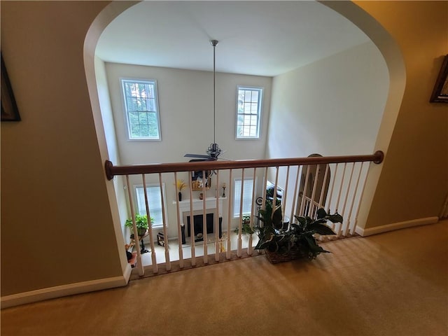 interior space featuring carpet floors, visible vents, baseboards, and arched walkways