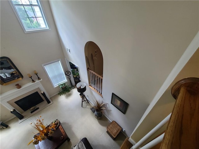 living room with a towering ceiling, visible vents, stairway, and arched walkways